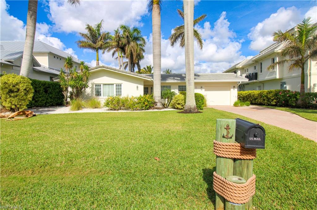 1353 Pelican Avenue Naples, FL 34102 - Photo 2 of 41 a front view of a house with a garden and yard