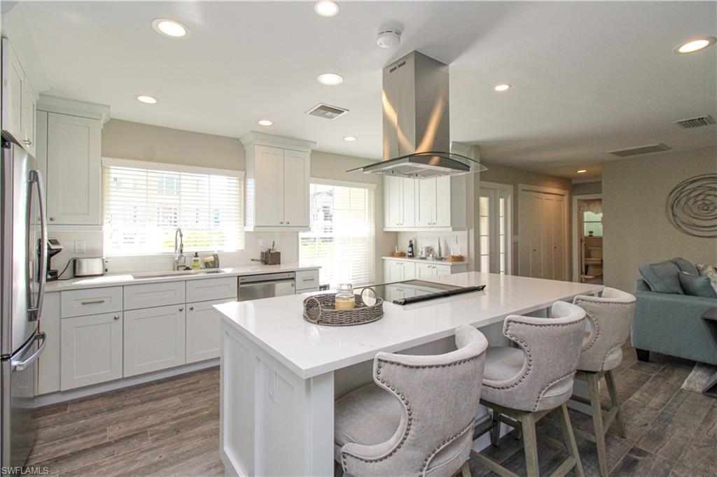 1353 Pelican Avenue Naples, FL 34102 - Photo 26 of 41 a kitchen with a dining table chairs sink and wooden floor