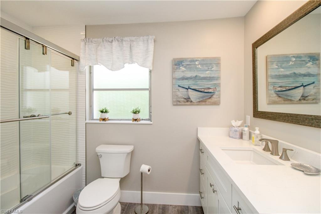 1353 Pelican Avenue Naples, FL 34102 - Photo 35 of 41 a bathroom with a granite countertop toilet a sink and a large mirror