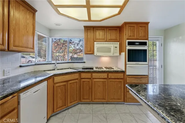 a kitchen with stainless steel appliances granite countertop a stove sink and refrigerator