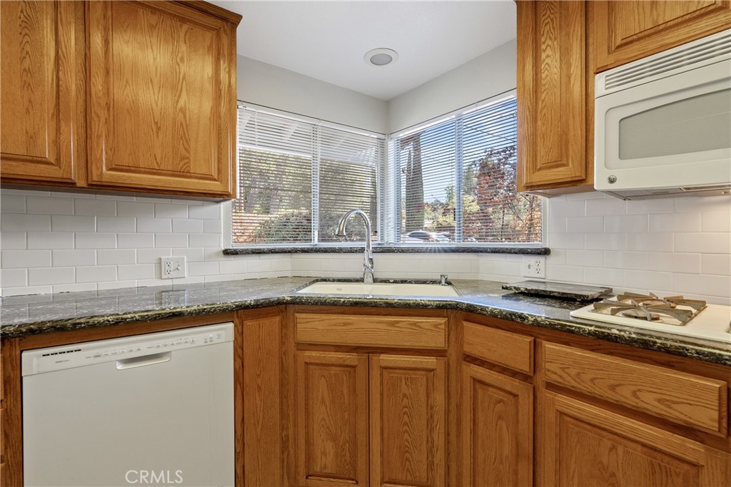 8120 Azucena Avenue Atascadero, CA 93422 - Photo 14 of 59 a kitchen with stainless steel appliances granite countertop a sink a stove cabinets and a window