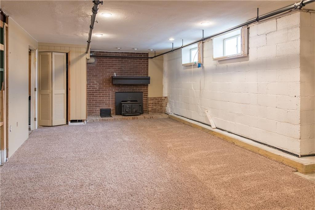 4041 Dickey Road Gibsonia, PA 15044 - Photo 20 of 23 This is just a small portion of the lower level. There's WAY more to see including a laundry space, work room and a third full bath with a tiled shower. French drains and a sump pump ensure dryness while a wood burning stove keeps the space toasty! This space lends itself well to an industrial theme but could also work with more traditional walls and furnishings. Unleash your creativity and make it your own!