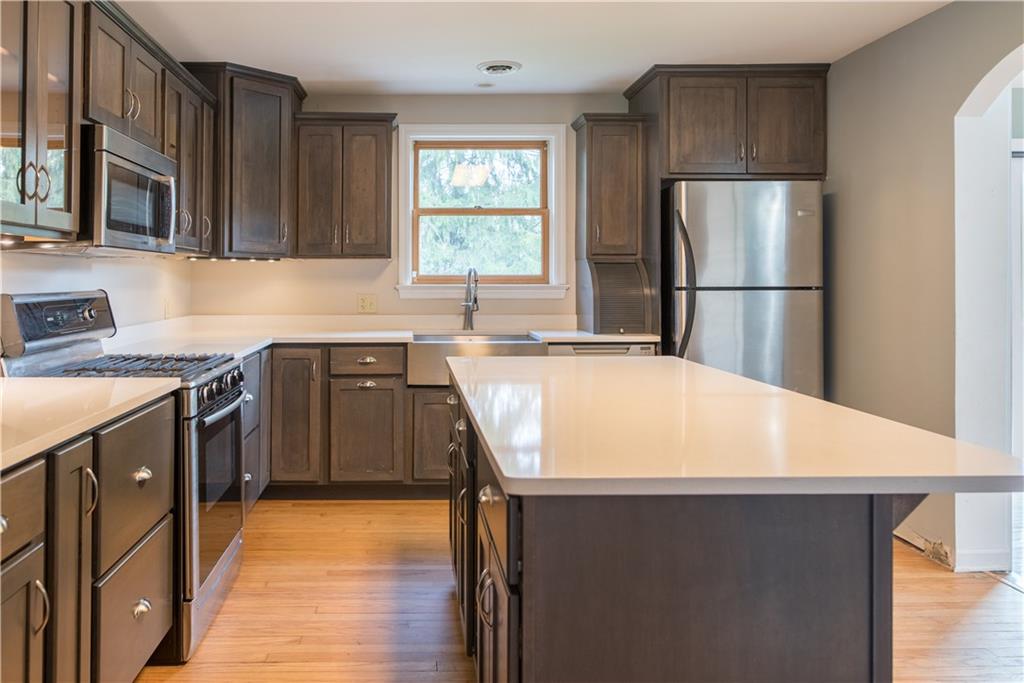 4041 Dickey Road Gibsonia, PA 15044 - Photo 7 of 23 Pictures cannot do justice to this fabulous high quality custom kitchen. The cabinet and counter space is extremely plentiful and all the shelving inside is natural maple WOOD. There is a double wide pantry to the left of the cabinets shown. Highlights include a Bosch gas stove and microwave, a super deep stainless sink and a wine rack in the island.