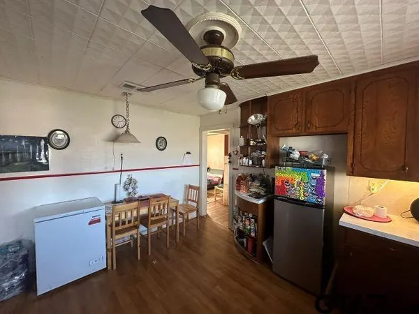 a kitchen with stainless steel appliances granite countertop a stove top oven a sink a dining table and chairs with wooden floor
