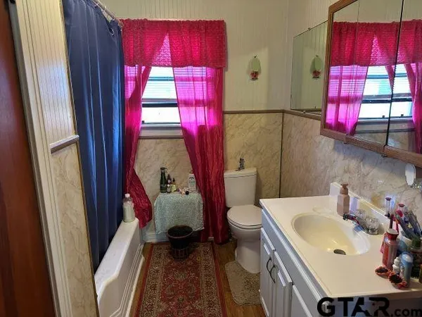 a bathroom with a sink toilet and window