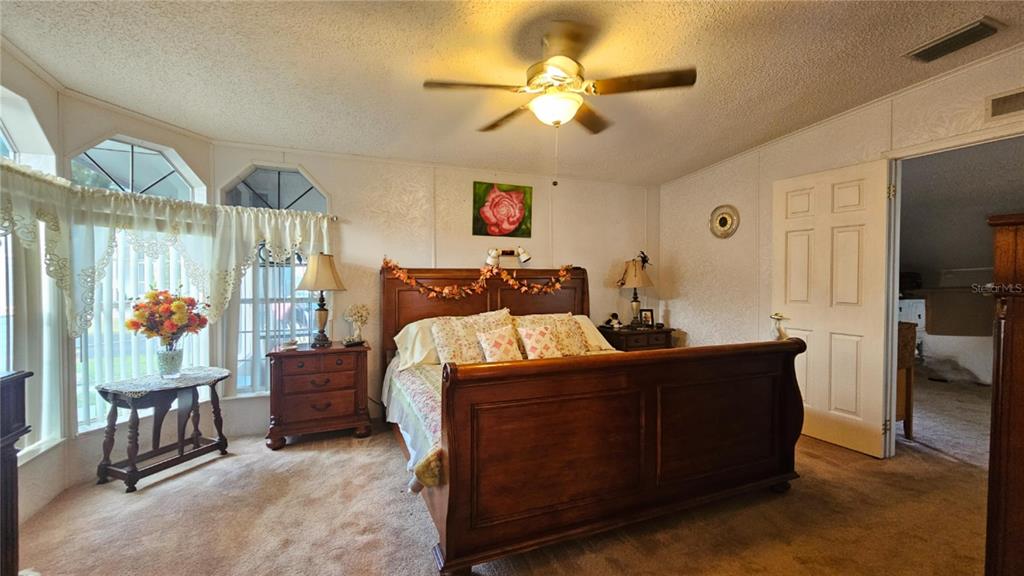 8210 Bull Run Drive New Port Richey, FL 34653 - Photo 18 of 30 a bedroom with a bed and a chandelier