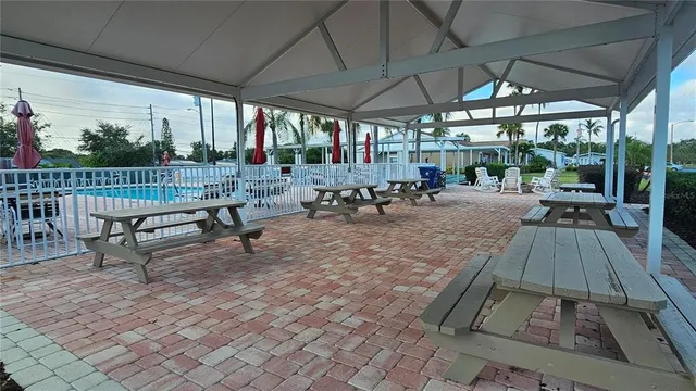 a view of a patio with table and chairs under an umbrella with a small yard