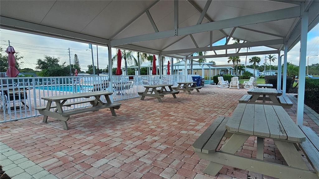 8210 Bull Run Drive New Port Richey, FL 34653 - Photo 23 of 30 a view of a patio with table and chairs under an umbrella with a small yard