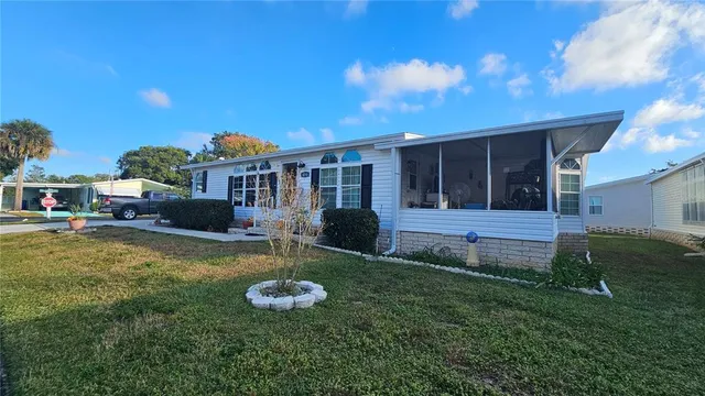 a view of a house with backyard and sitting area