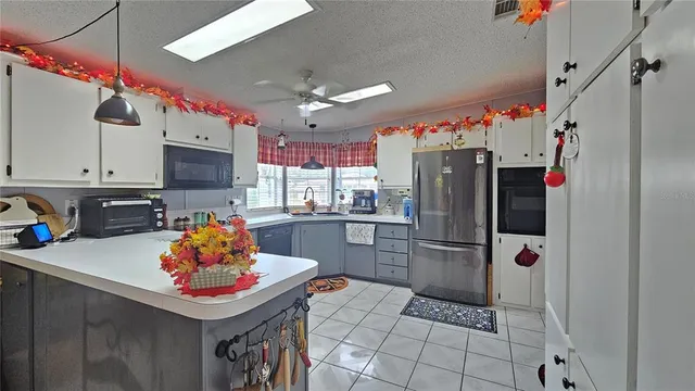 a kitchen with stainless steel appliances a refrigerator sink and microwave