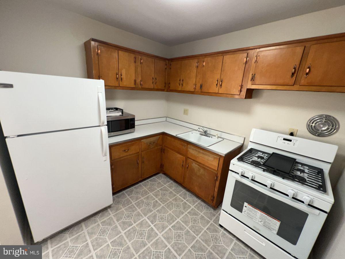 1002 Taney Avenue, Unit 1002 Frederick, MD 21702 - Photo 4 of 7 a kitchen with a refrigerator stove and cabinets