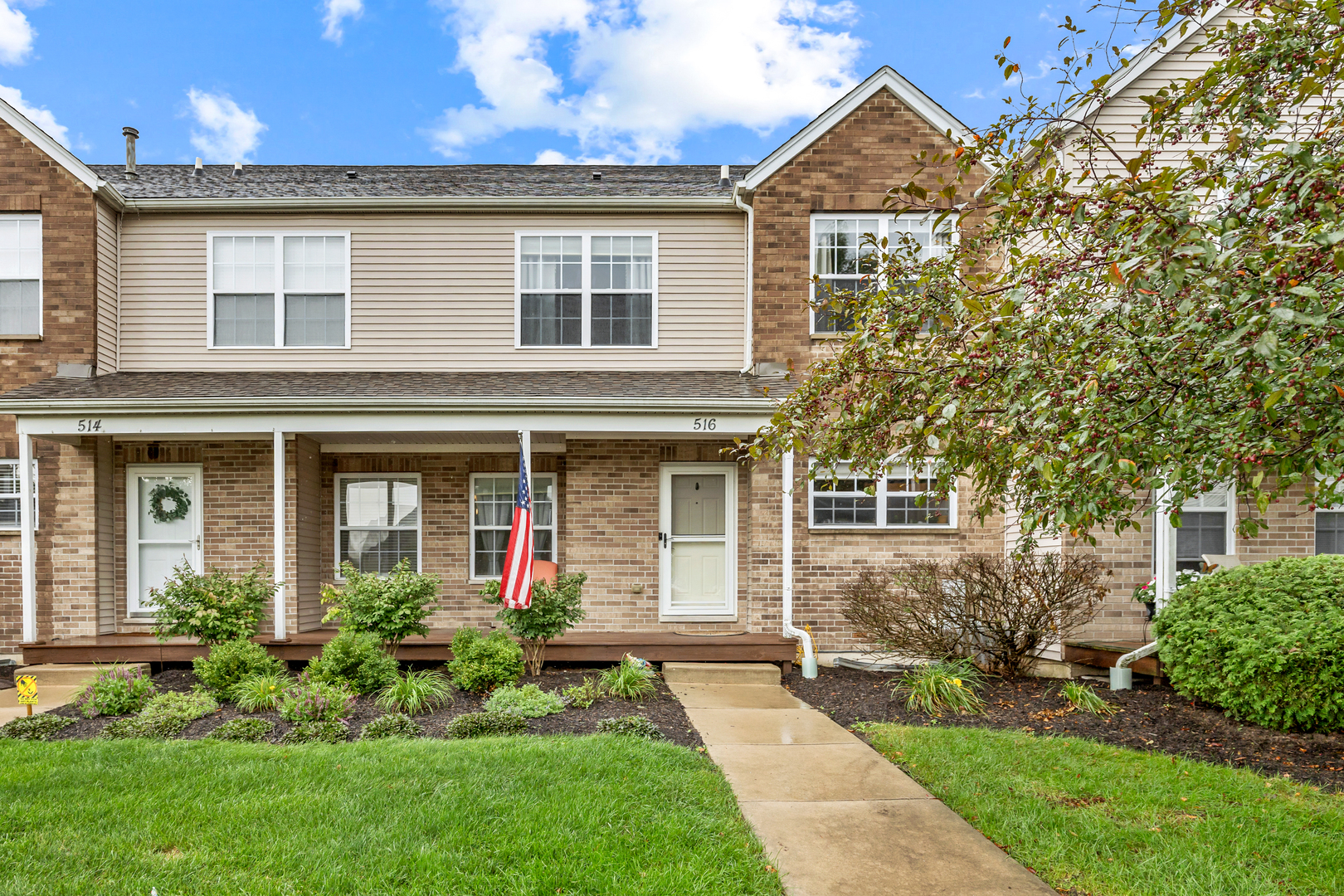 a front view of a house with a yard and potted plants