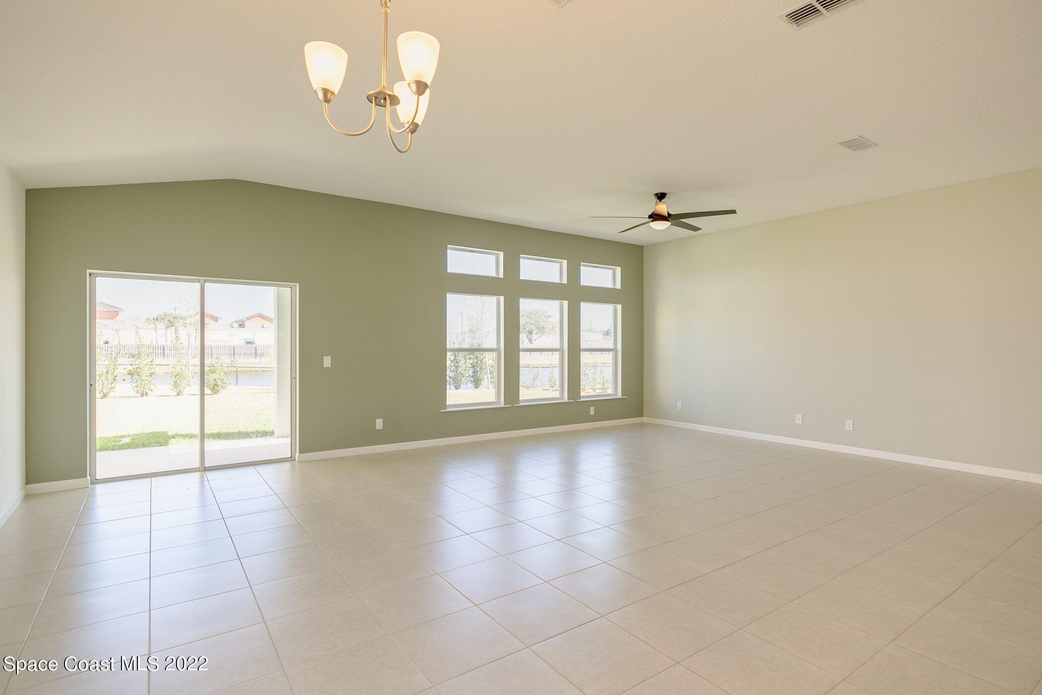 3555 Tabitha Court Melbourne, FL 32934 - Photo 12 of 30 an empty room with chandelier fan and windows