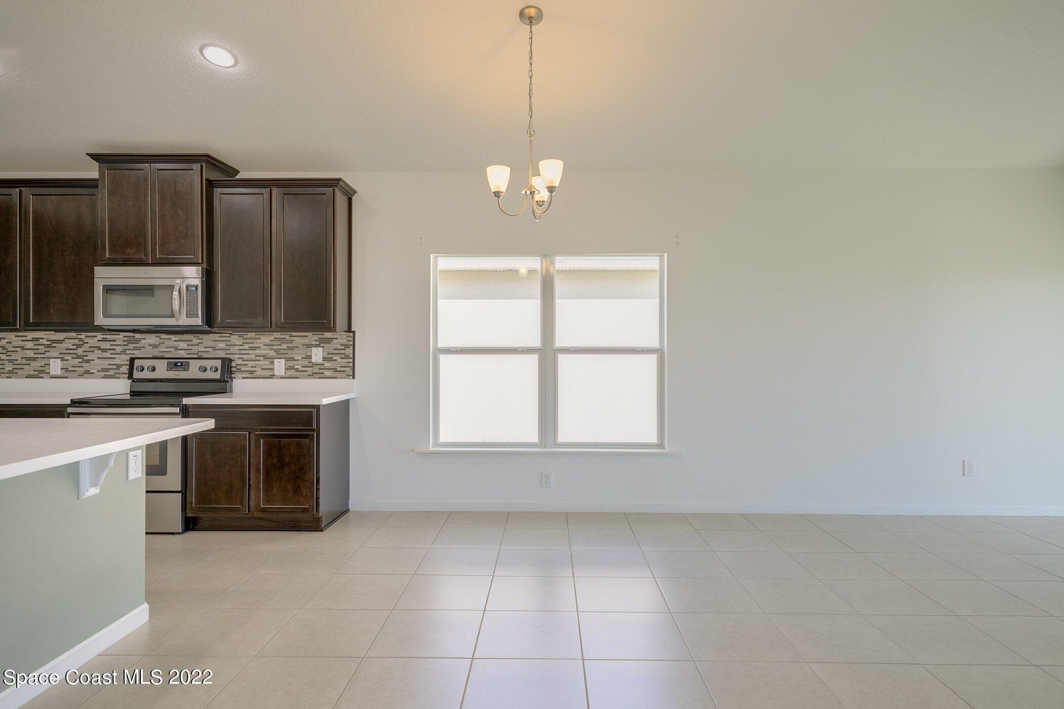3555 Tabitha Court Melbourne, FL 32934 - Photo 15 of 30 a kitchen with stainless steel appliances granite countertop a stove a sink and a refrigerator