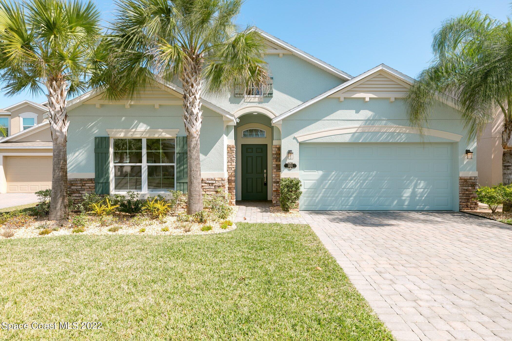 3555 Tabitha Court Melbourne, FL 32934 - Photo 2 of 30 a front view of a house with large windows and palm trees
