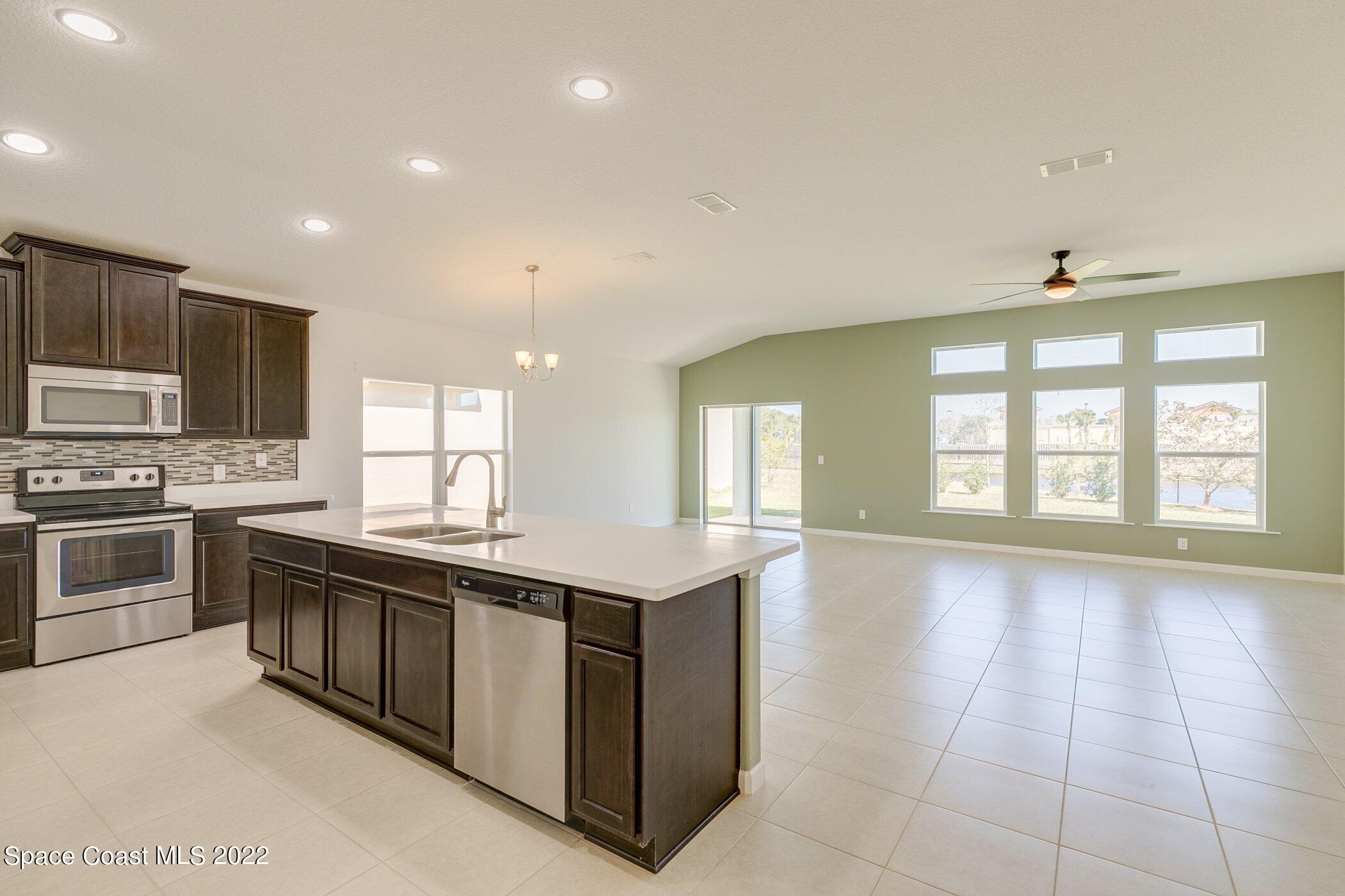 3555 Tabitha Court Melbourne, FL 32934 - Photo 5 of 30 a large kitchen with stainless steel appliances granite countertop a stove and a sink