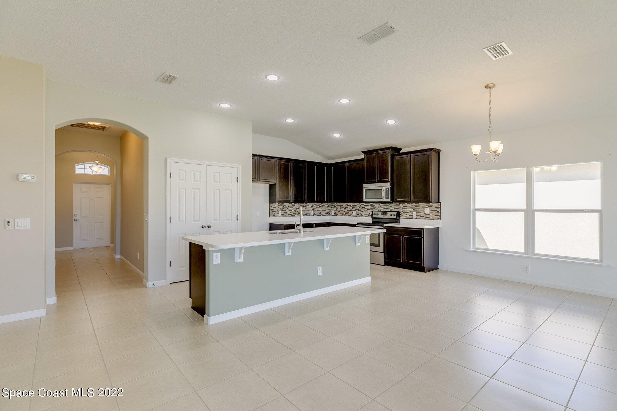 3555 Tabitha Court Melbourne, FL 32934 - Photo 6 of 30 a large white kitchen with a white stove top oven and cabinets