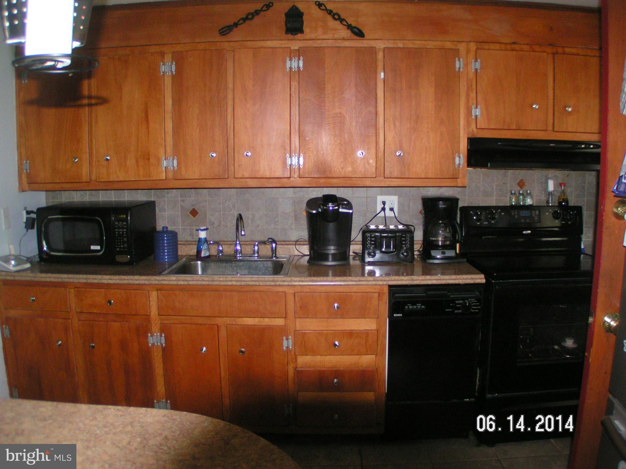 7413 Forrest Avenue Baltimore, MD 21234 - Photo 2 of 14 a kitchen with stainless steel appliances granite countertop a sink a stove and a microwave oven