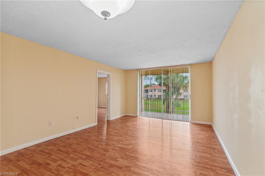225 Turtle Lake Court, Unit 209 Naples, FL 34105 - Photo 2 of 15 a view of an empty room with wooden floor and a window
