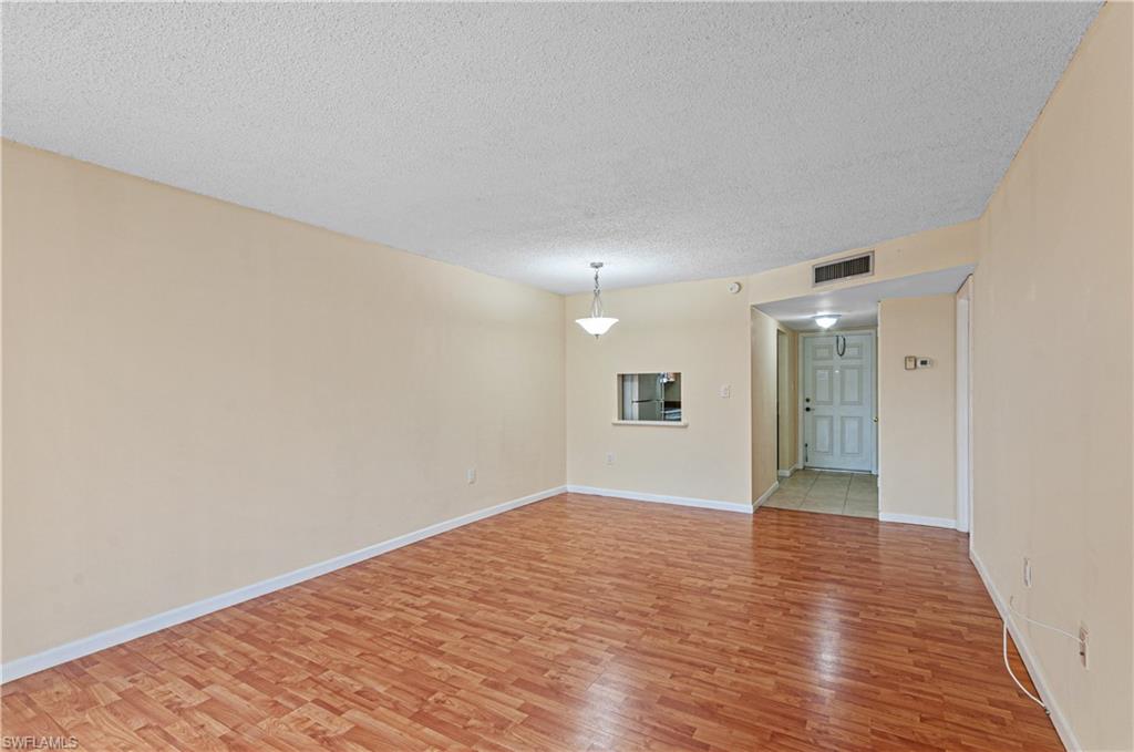 225 Turtle Lake Court, Unit 209 Naples, FL 34105 - Photo 4 of 15 a view of an empty room with wooden floor