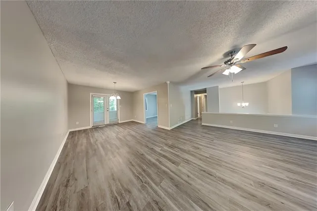 a view of an empty room and window and wooden floor