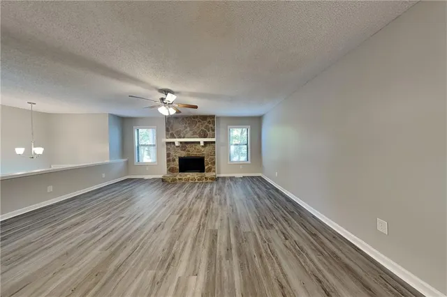 a view of empty room with a fireplace and wooden floor