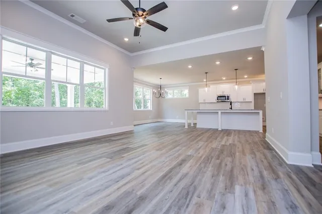 a view of an empty room with wooden floor fireplace and a window