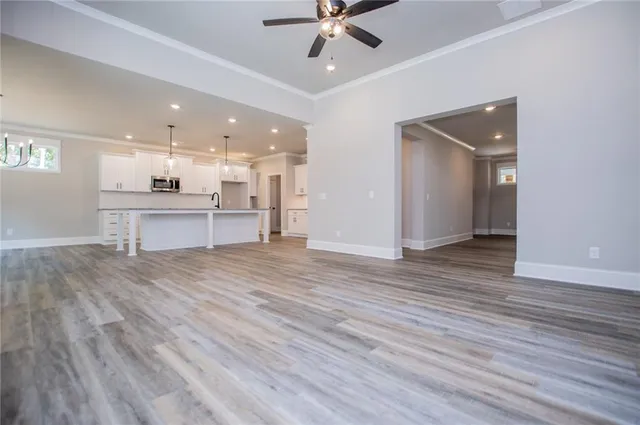 a large kitchen with granite countertop a large counter top a sink stainless steel appliances and cabinets