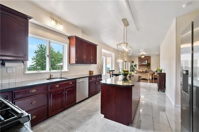 a kitchen with stainless steel appliances granite countertop wooden cabinets a stove top oven a sink and dishwasher