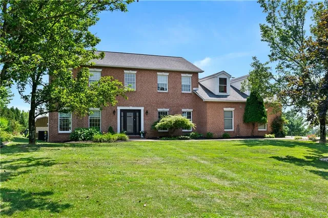 a view of a green field with trees in the background