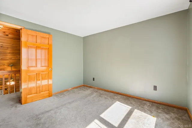 an empty room with a bathroom and a window