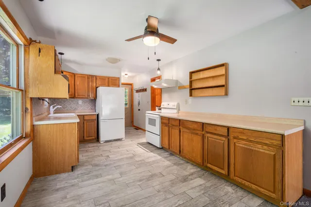 a white kitchen with a sink a refrigerator a stove a washer dryer and cabinets