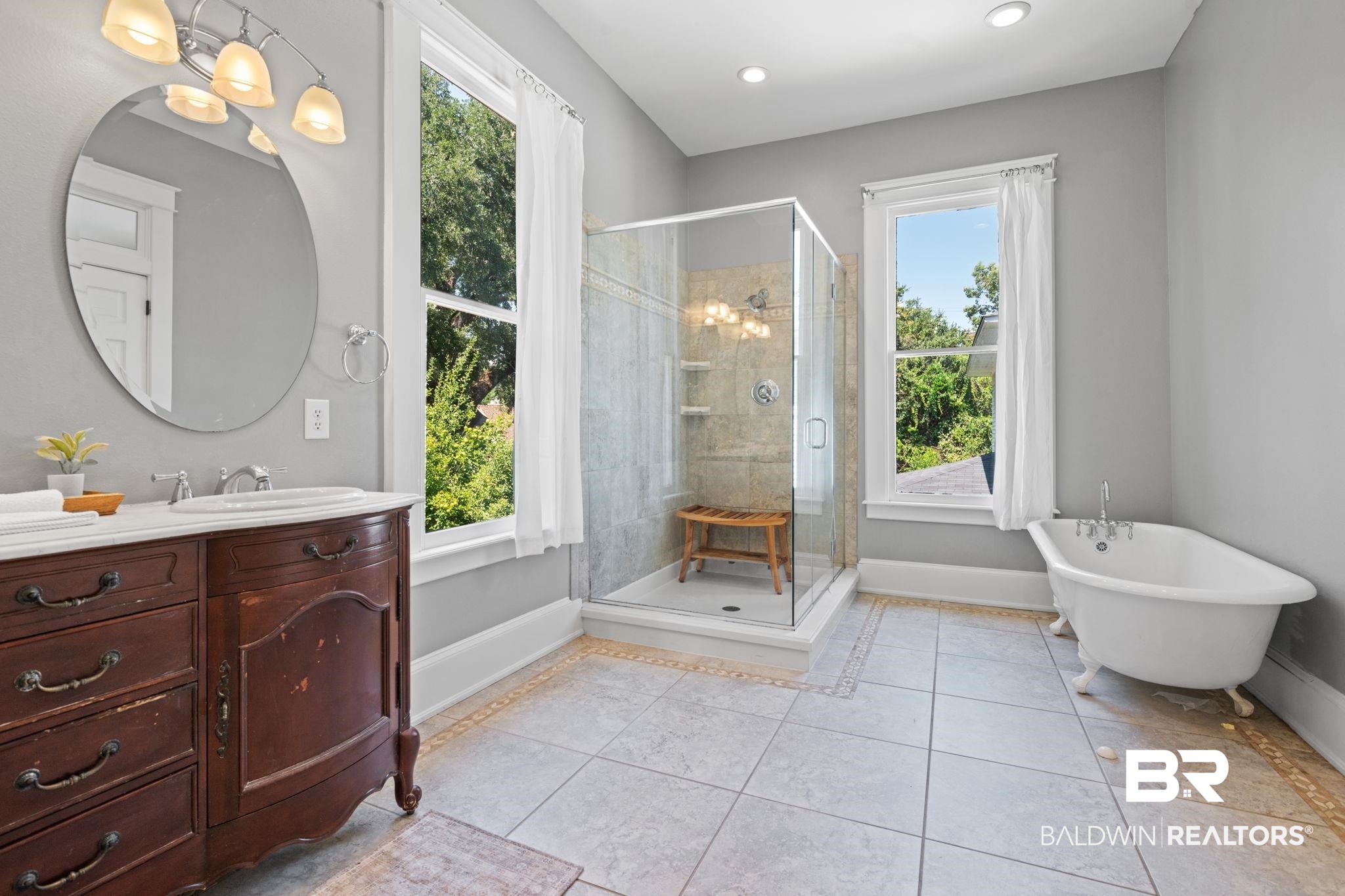 10 South Monterey Street Mobile, AL 36604 - Photo 23 of 45 Full bath featuring vanity, a freestanding tub, a stall shower, light tile patterned floors, and a chandelier