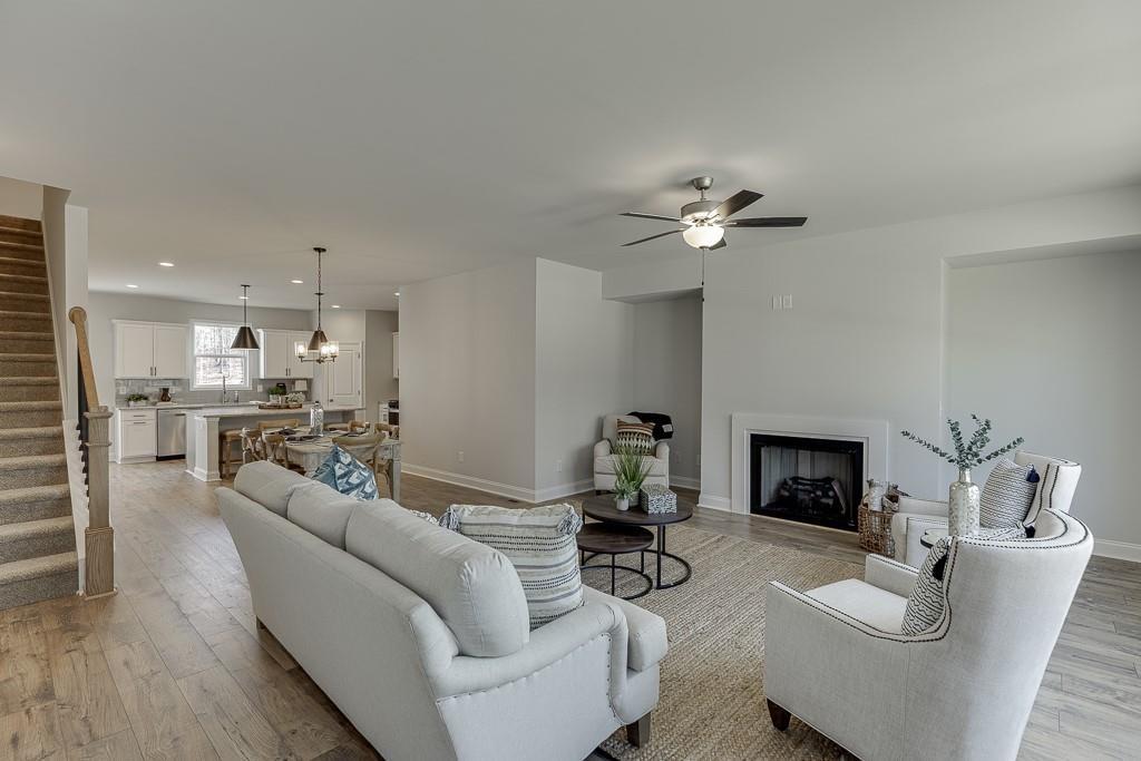 1276 Ainsworth Alley Sugar Hill, GA 30518 - Photo 15 of 56 a living room with furniture a fireplace and a ceiling fan