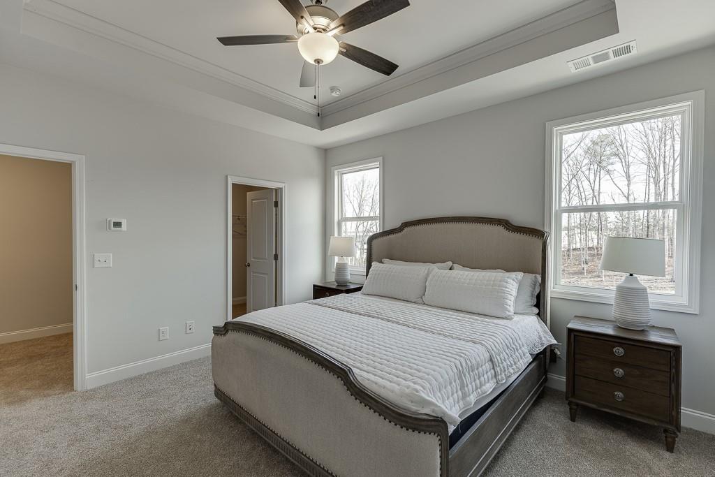 1276 Ainsworth Alley Sugar Hill, GA 30518 - Photo 22 of 56 a bedroom with a large bed and a window