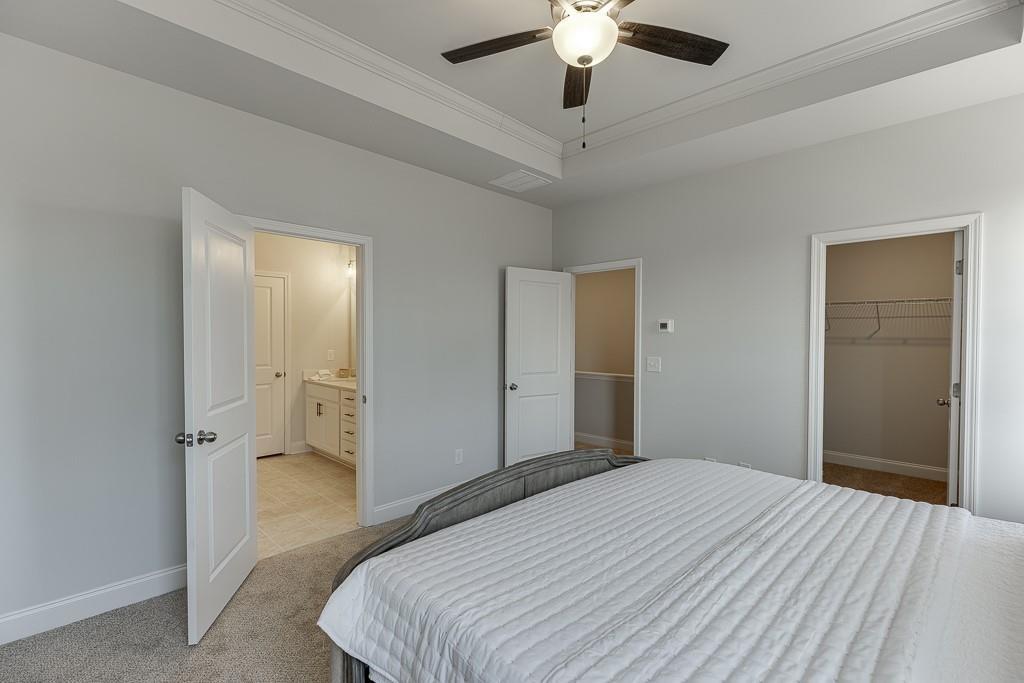 1276 Ainsworth Alley Sugar Hill, GA 30518 - Photo 23 of 56 a bedroom with a bed and a chandelier