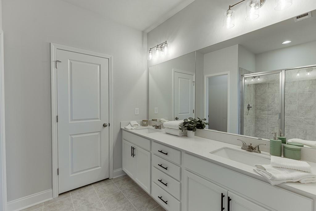 1276 Ainsworth Alley Sugar Hill, GA 30518 - Photo 25 of 56 a bathroom with double sink and a mirror
