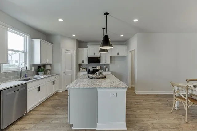 a kitchen with stainless steel appliances granite countertop a sink stove and refrigerator