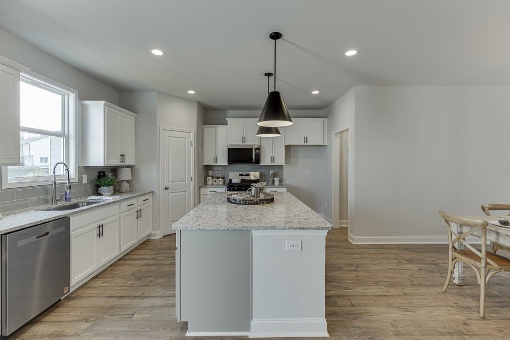 1276 Ainsworth Alley Sugar Hill, GA 30518 - Photo 8 of 56 a kitchen with stainless steel appliances granite countertop a sink stove and refrigerator