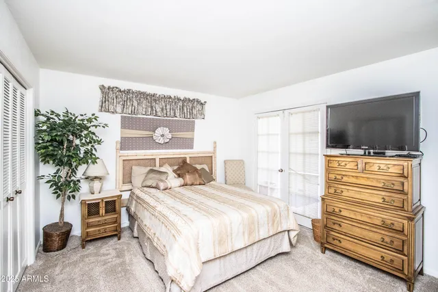 a spacious bedroom with a bed and a television in it
