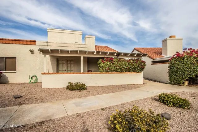 a view of a swimming pool with lawn chairs and plants