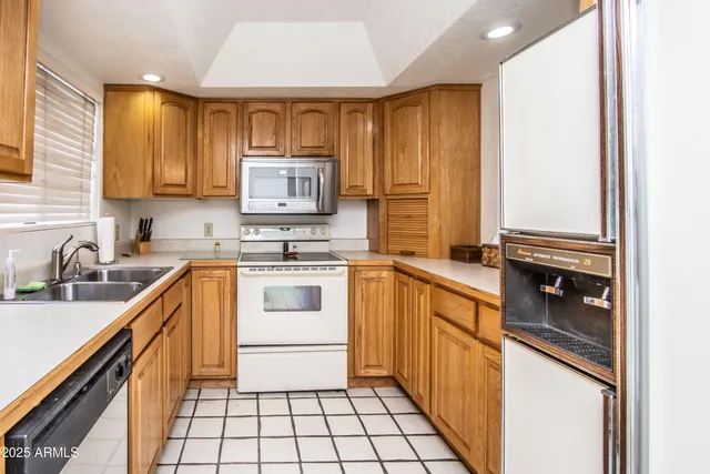 a kitchen with stainless steel appliances white cabinets a sink and a window