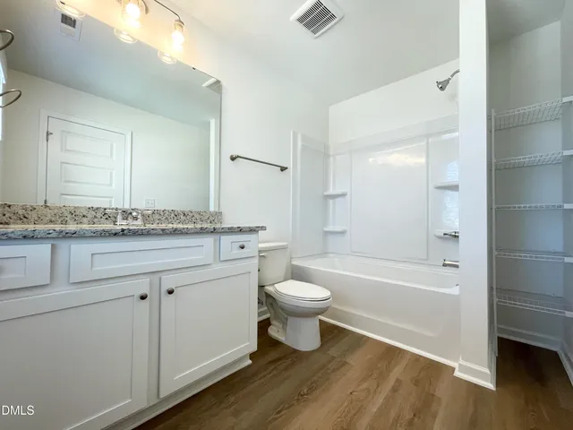 a bathroom with a granite countertop toilet a sink and bathtub