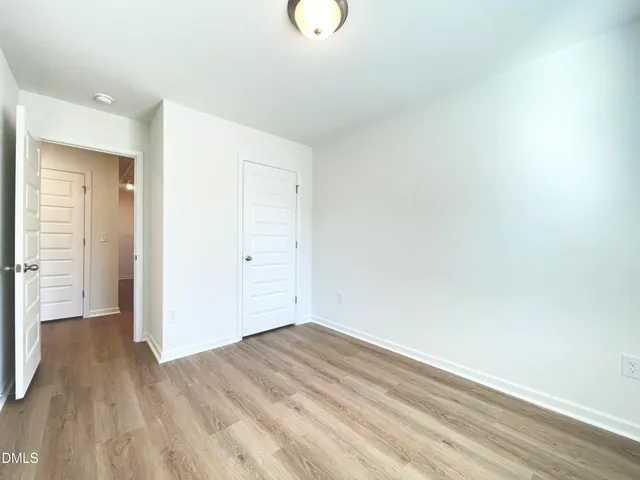 a view of a room with wooden floor and white doors