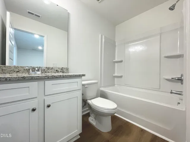 a bathroom with a granite countertop toilet a sink and bathtub