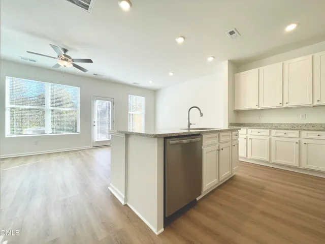 a kitchen with granite countertop white cabinets and white appliances