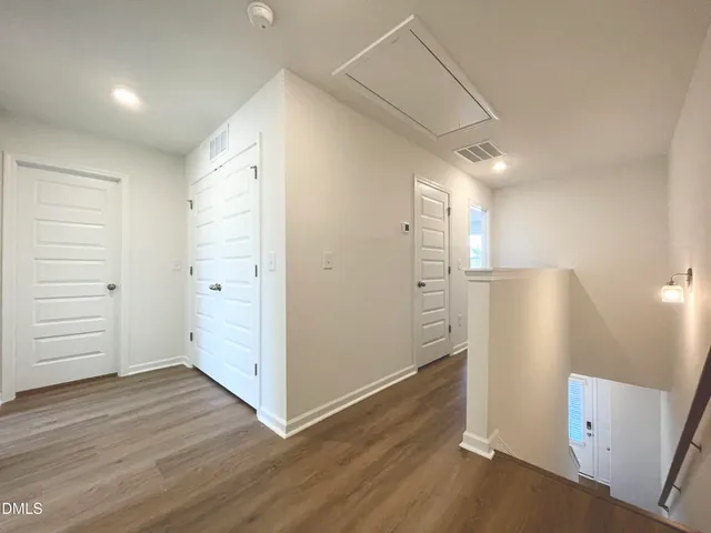 an empty room with wooden floor and cabinet