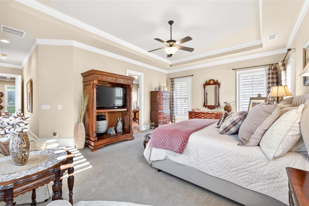 403 Tralee Court Statham, GA 30666 - Photo 40 of 98 a bedroom with a bed a chandelier and a mirror on a dresser