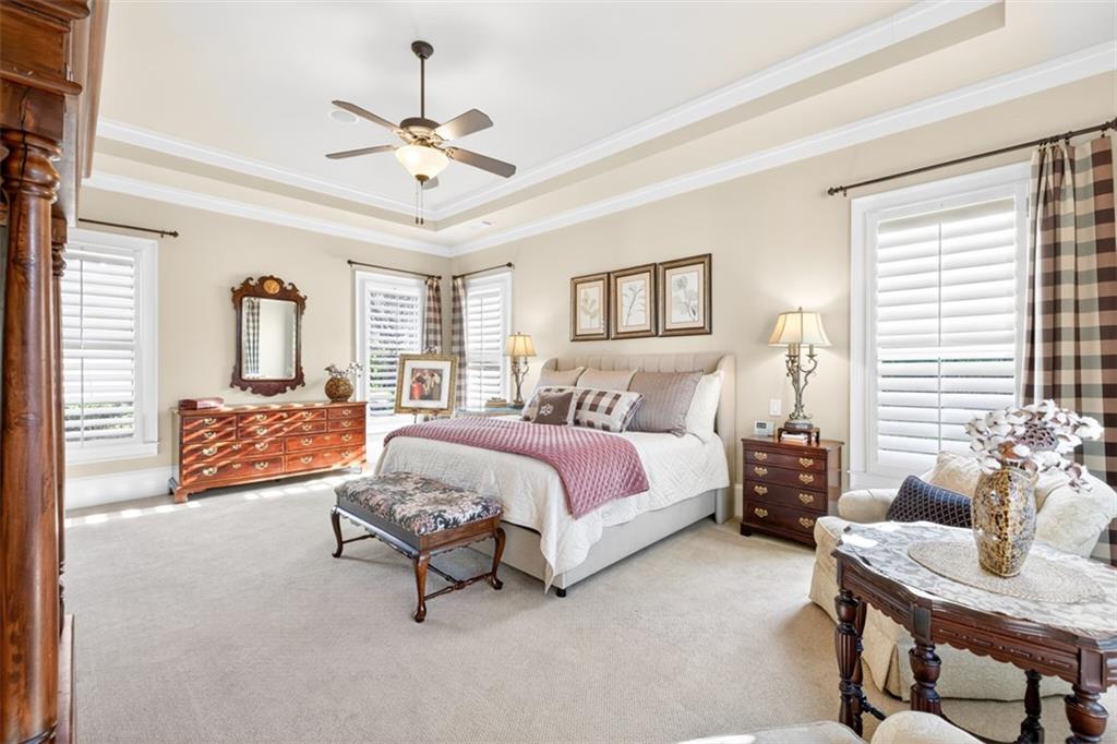 403 Tralee Court Statham, GA 30666 - Photo 47 of 98 a spacious bedroom with a bed and a chandelier