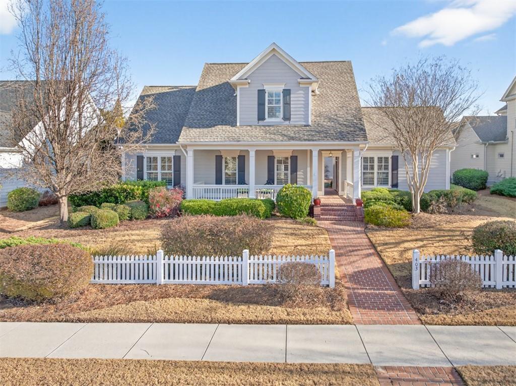 403 Tralee Court Statham, GA 30666 - Photo 76 of 98 a view of a brick house next to a yard with potted plants and trees